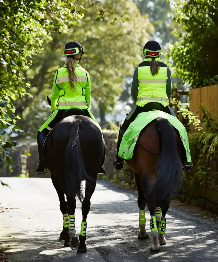 Two ladies hacking wearing HiVis