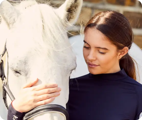 Girl stroking grey pony